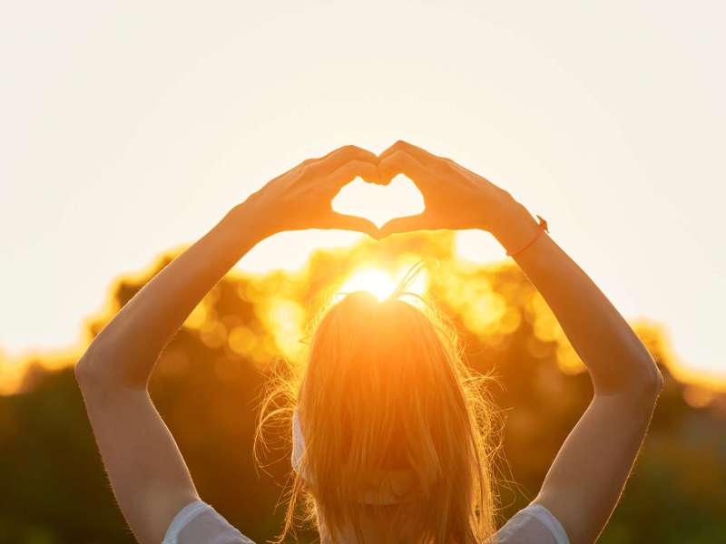 Woman in nature holding heart-shape symbol made with hands. Woman in nature holding heart-shape symbol made with hands.